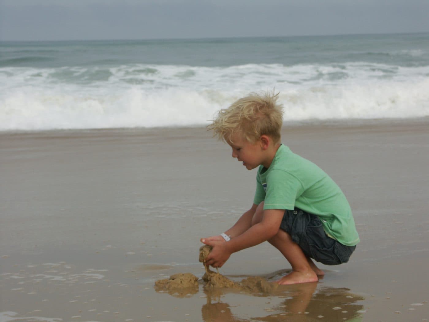 Kind speelt aan de waterlijn op het strand - voor iedereen