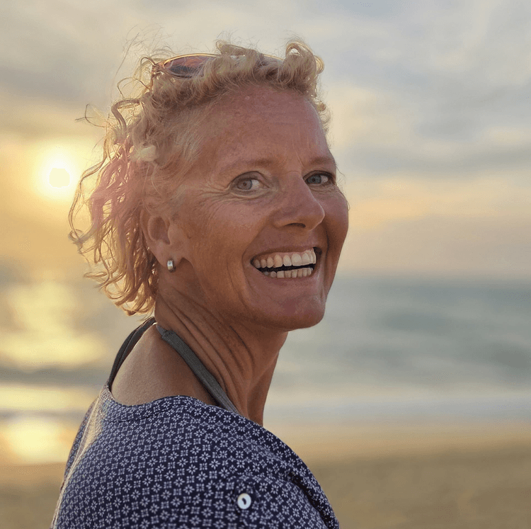 Simone Nieuwhuis - coach voor kleine en grote mensen, lachend op het strand bij zonsondergang