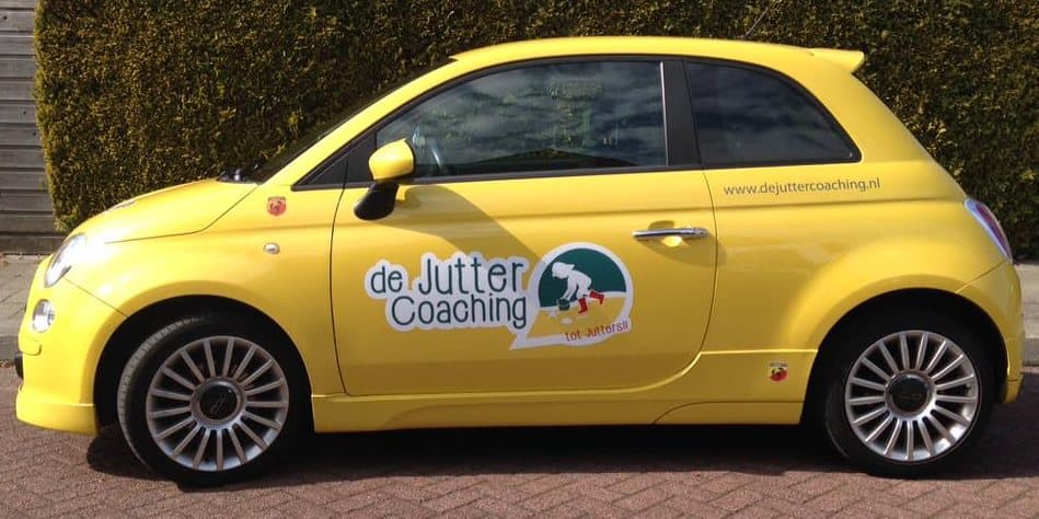 De knalgele Fiat 500 van de Jutter Coaching op de oprit